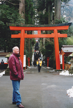 Fr. John Carten in front of the Torii Gate at the entrance of the Hakone Shinto Shrine in Hakone National Park outside of Tokyo.