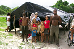 Sr. Clarice Garvey with one of the 400 families camped on the roadside of a highway in the municipality of Chorozinha in the Brazilian State of Ceará since last November. They await the government's decision on their request for ownership of 12,000 hectares of land unused by the present owner. While they wait, the families must remain near the land, returning to the fields each day to tend their crops. By law they are permitted to keep 85% of the yield. During the heavy rains that came this year and the torrid sun blazing down on the thick black plastic tents they call home, the people have not complained about the government's delay, and have maintained a spirit of community, hope and peace.