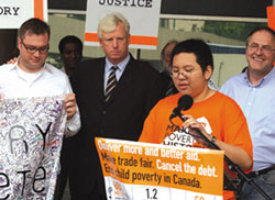 Joshua Liu addresses the crowd at the first anniversary of Live 8. Behind Joshua are Stephen Page of the Barenaked Ladies, Toronto Mayor David Miller and Gerry Barr, co-Chair of the Make Poverty History campaign. Toronto. June 2006