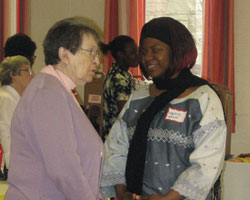 (CREDIT Becoming Neighbours) Menyi Ndua of Cameroon, Africa, and Notre Dame Sr. Jenny Nasello chat at the Becoming Neighbours Spring Festival where 80 newcomers, companions and prayer partners enjoyed an intercultural exchange. April 2007
