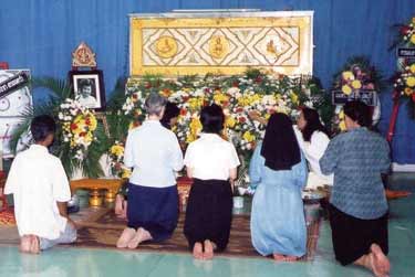 Praying with the monks and before the coffin at Nok's mother's burial ritual.