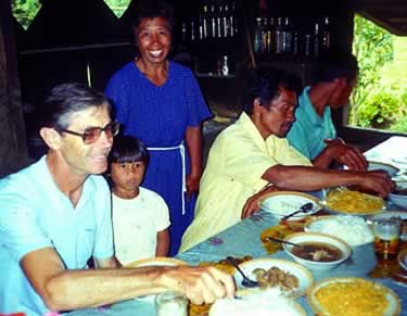 Fr. Jim McGuire shares a meal with a family in the Philippines where he served for 32 years.