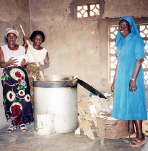 Sister Beatrice Chipeta at the Nutrition Centre with volunteer cooks using an environmentally friendly stove. The Nutrition Centre and nursery school are two of many programs of the Lusubiro Project, all supported by volunteers from the communities and villages of Karonga, Malawi.