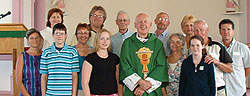 Family members gather with Scarboro missioner Fr. Gerald Curry to celebrate a memorial mass on the 40th anniversary of the death of Fr. Art MacKinnon. St. Alphonse Church, Low Point, Cape Breton.