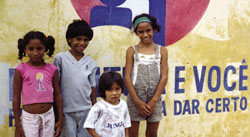 Luciano, his two sisters and their little brother Lukinho at the community library, a favourite place to visit. Planalto do Pici, Brazil.
