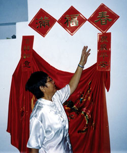 Sr. Lucy Lee translates the writings on the wall hangings, which carry wishes for Chinese New Year blessings of peace and happiness for all the years to come.