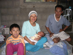 Pen and Baan with their son Dton and new baby during a visit with Scarboro missioner Susan Keays who was helping them to learn English. By Canadian standards they had so little, but they generously shared with Susan the little they had.