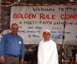 J.W. Windland stands beside a young man in clothing worn by men during the Muslim Hajj (pilgrimage to Mecca). JW is a resource person for the Scarboro Interfaith Desk assisting with several interfaith events.
