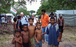 Sr. Clarice Garvey stands beside Raimundao, a community leader. These people are part of a group of 700 families who are camped on a roadside in Chorozinho, Ceara. They await final government approval for ownership of Uruanan, an 11,000 hectare caju farm. Also pictured is Mr. Marius deBruyn, a visitor from Canada.