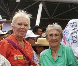 Sr. Clarice Garvey stands beside Raimundao, a community leader. These people are part of a group of 700 families who are camped on a roadside in Chorozinho, Ceara. They await final government approval for ownership of Uruanan, an 11,000 hectare caju farm. Also pictured is Mr. Marius deBruyn, a visitor from Canada.