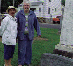 Srs. Norma Samar and Rosemary Hughes who along with Sr. Frances Brady serve on Our Lady's Missionaries' leadership team, visit the grave of Fr. Dan Macdonald, founder of their community. Alexandria, Ontario.