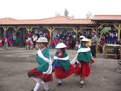 Children dance in front of their beautiful new school during the inauguration ceremonies. The whole community helped build the school and were present for the celebrations. Huanca Pallaguchi, Ecuador. Photo by Tom Walsh.