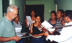 Fr. Lou and the church choir serenading the St. Joseph Catholic Secondary School mission group in the early morning hours. 2001.