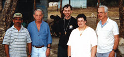A farmer from the community of Los Palmaritas welcomes (L-R) Fr. Tom Day, teacher Jim Lacey, Sr. Terry Ann Wilson and Fr. Lou Quinn. 1997. San José de Ocoa.