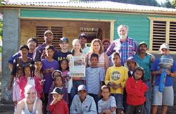 A job well done.  D.R.E.A.M.S. participants of St. Mary's high school in Hamilton, Ontario, with co
mmunity members in front of a new home they built in El Rifle, San José de Ocoa, Dominican Rep
ublic.  Kristin Stawiarski holds a copy of her hometown newspaper, the Ancaster News