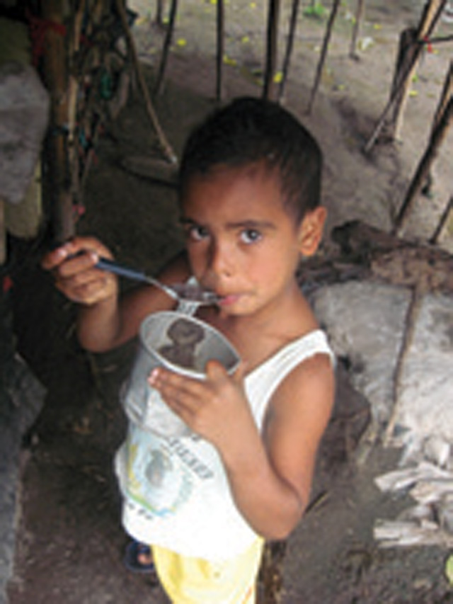 Eating a snack of dry manioc flour.